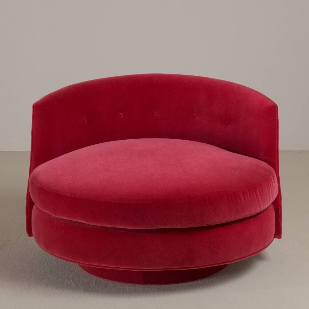 A swivel raspberry mohair velvet upholstered Love Chair by Talisman Bespoke.

Inspired by a Classic Mid-Century lounge chair, this generously proportioned design is ideal to curl up in. Available in a variety of fabrics, this chair can be adapted to