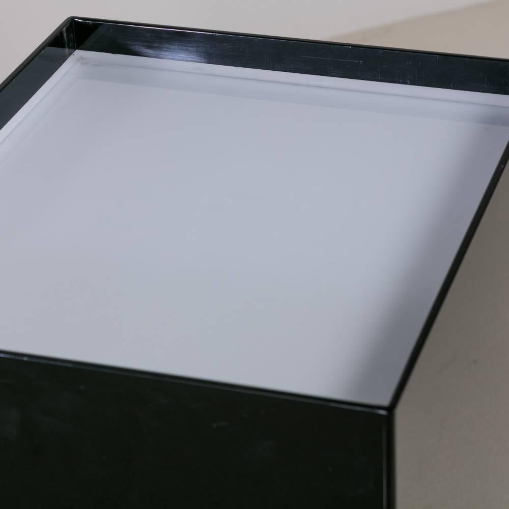 An oversized black and ivory acrylic lightbox pedestal
