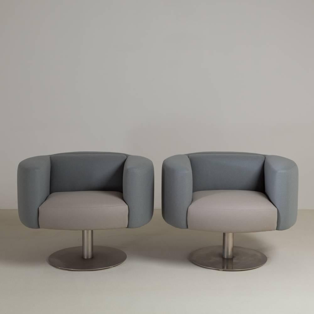 A pair of two-tone wool upholstered pedestal based swivel chairs reupholstered by Talisman.
