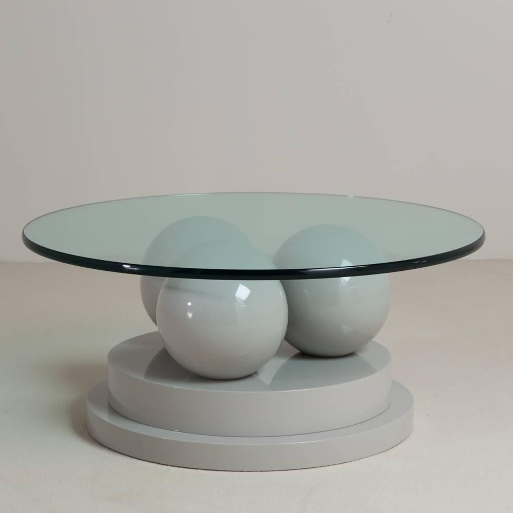 A sculptural post modernist grey lacquered coffee table, 1980s.

Base measurements provided, stock glass included in price, size to be confirmed on application.