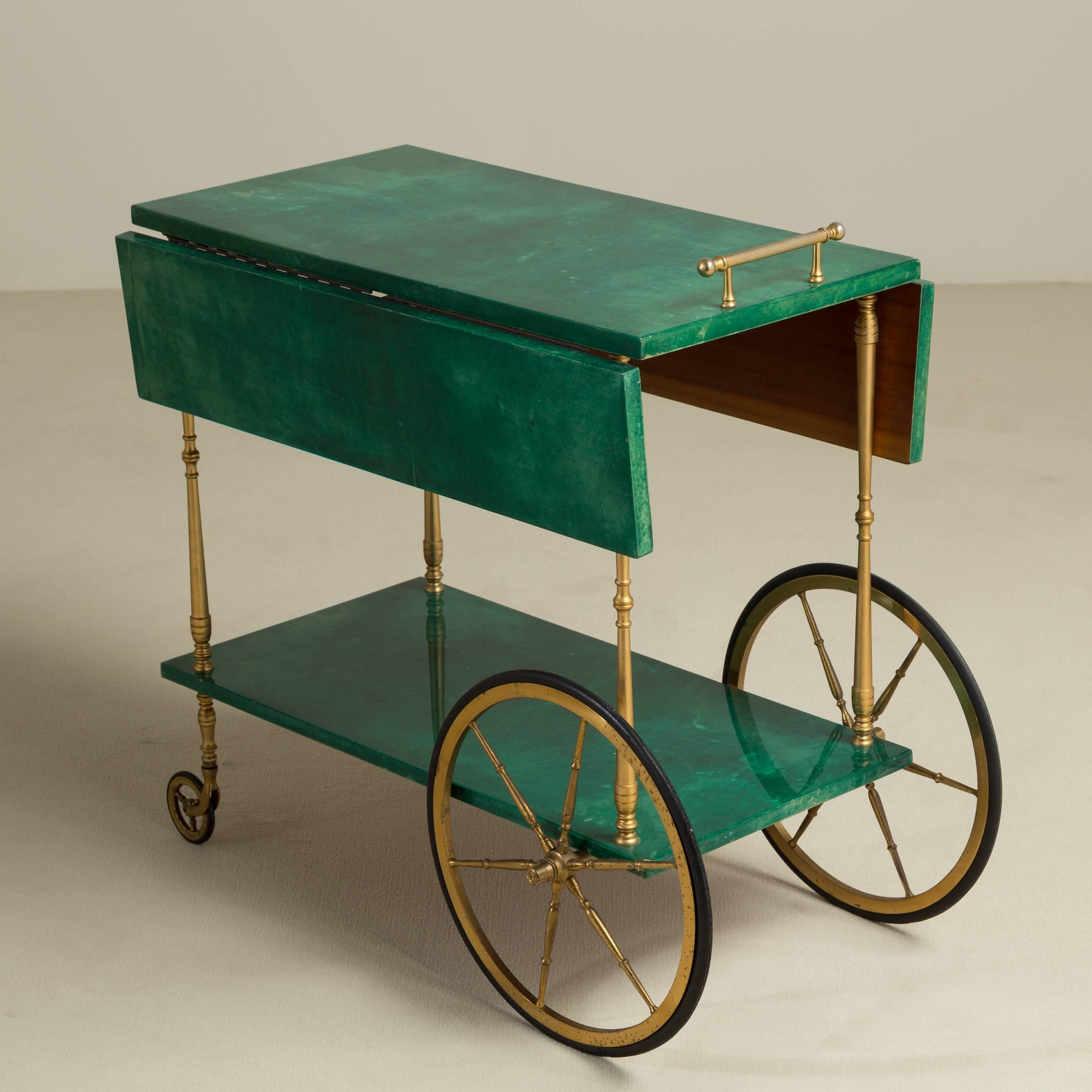 A rare two-tiered drop-leaf emereld green lacquered goatskin barcart designed by Aldo Tura with original brass metalwork, Italy, 1950s, stamped.

Prices include 20% VAT which is removed for items shipped outside the EU.