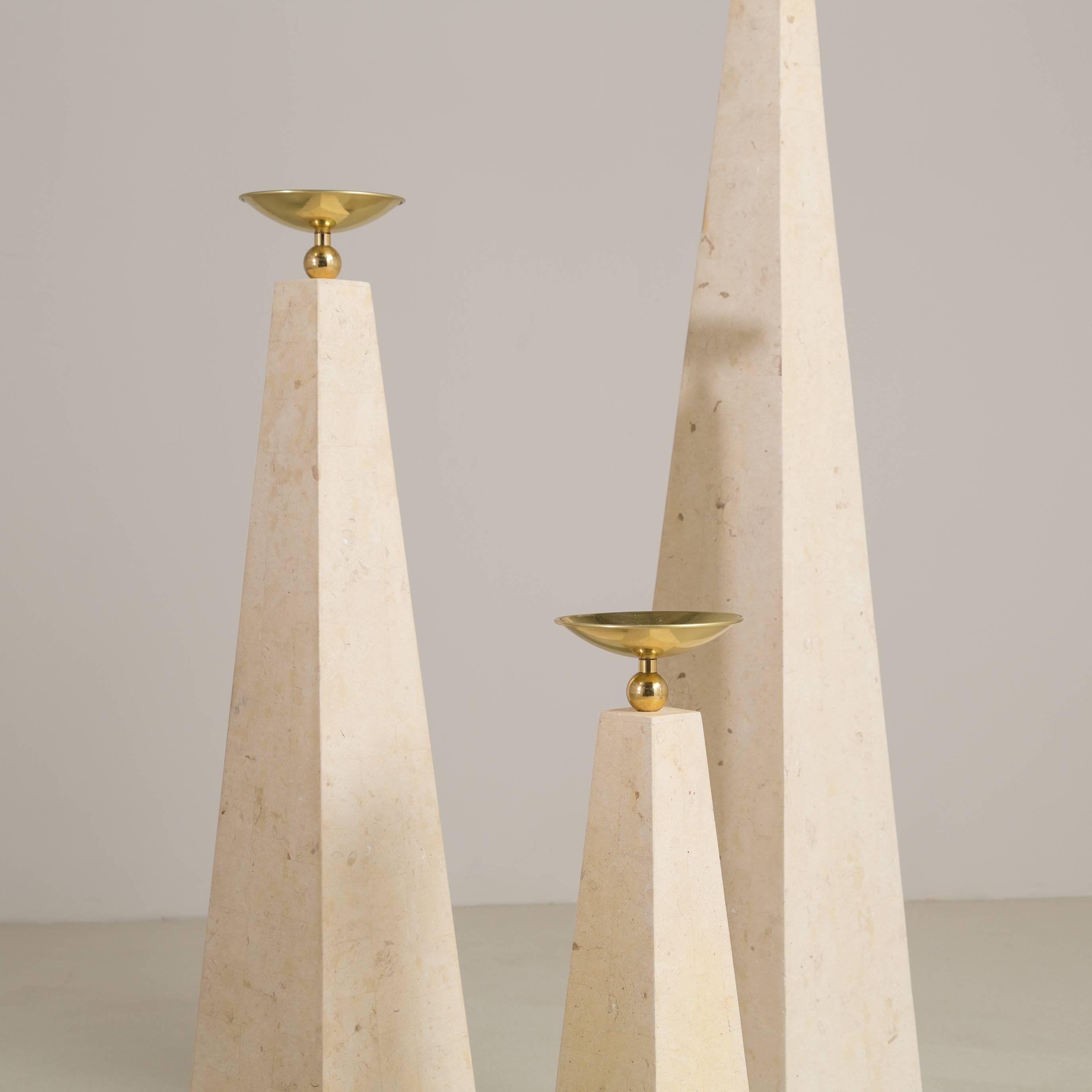 A set of three Maitland Smith designed stone veneered obelisk with brassed metal detail, 1980s.

Medium H 96cm, W 20cm, D 20cm.
Small H 65cm, W 16cm, D 16cm.
