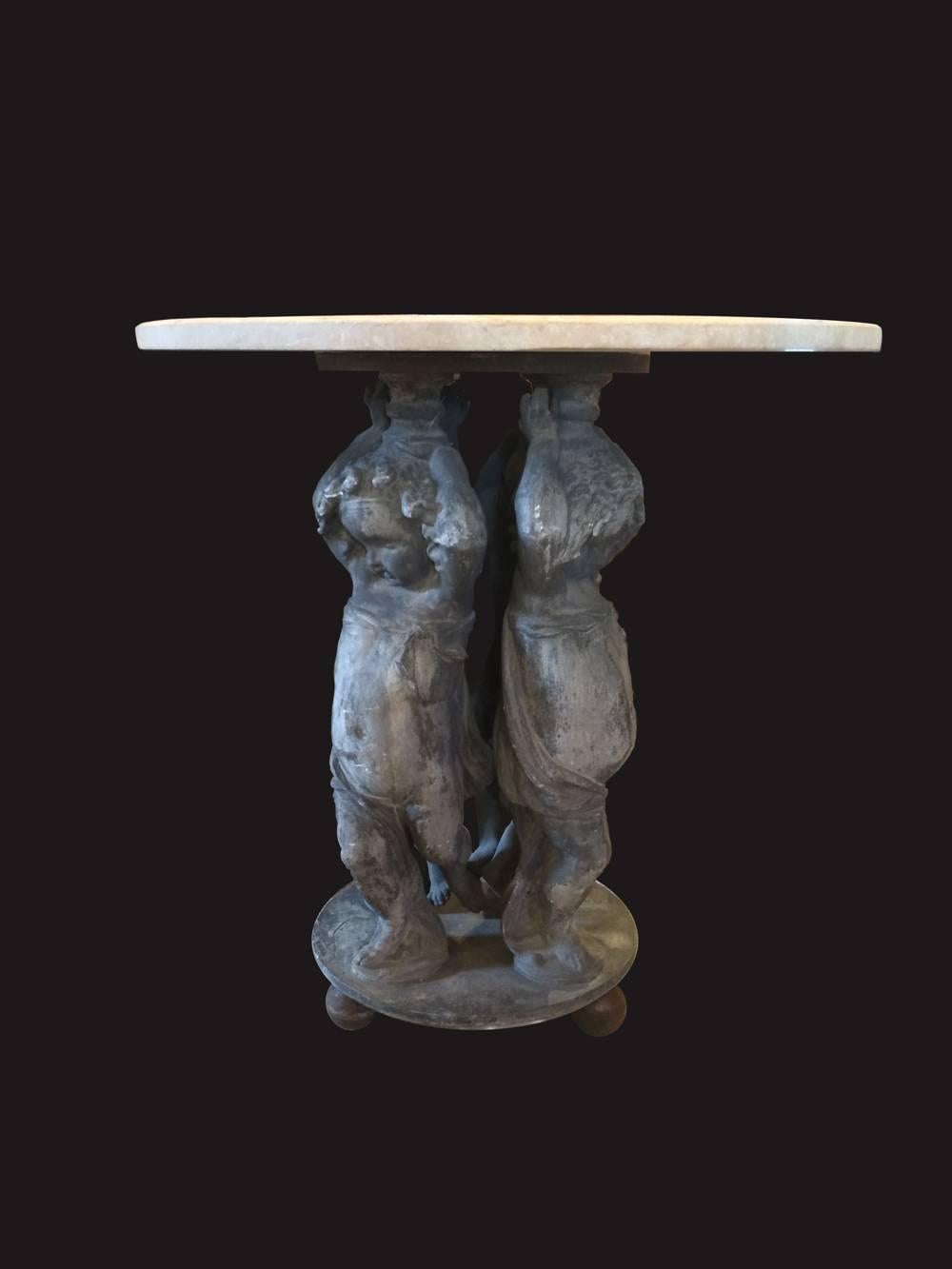 A fabulous and unique antique marble top garden table.  It is supported by four lead cherub figures with outstretched arms. The top has a wonderfully aged patina. It is one of the most unusual and rare tables we have ever offered.  Circa 1880.