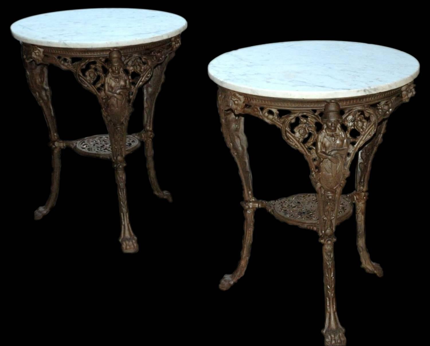 French, circa 1880's cast iron figural garden tables. The tables have round marble tops and cast iron bases. They could function well indoors as side tables or outdoors as garden tables. Each leg is adorned with a woman holding a shield terminating