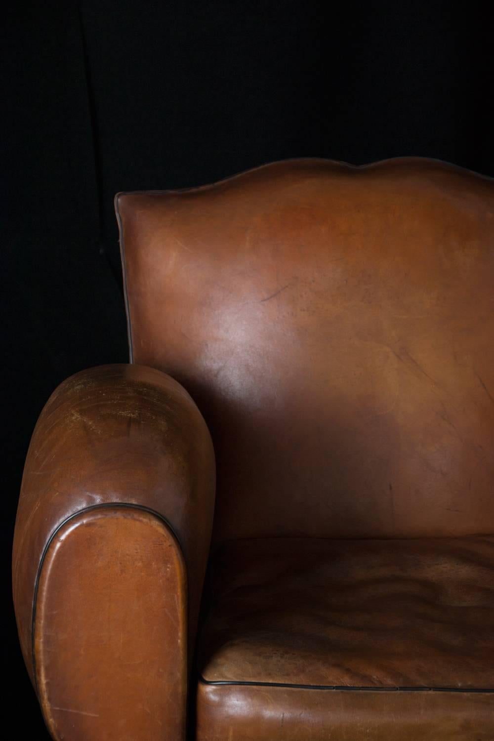 Vintage pair of mustache club chairs, circa 1930s. Beautifully aged leather.

 