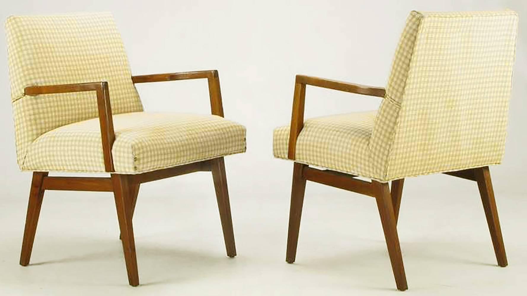The designer of these chairs slightly distorted their proportions to create intriguing seating that is sculptural in feel. The backs are a polygons with just the slightest arc in the seat backs as they taper to the top. Carved walnut arms are wider