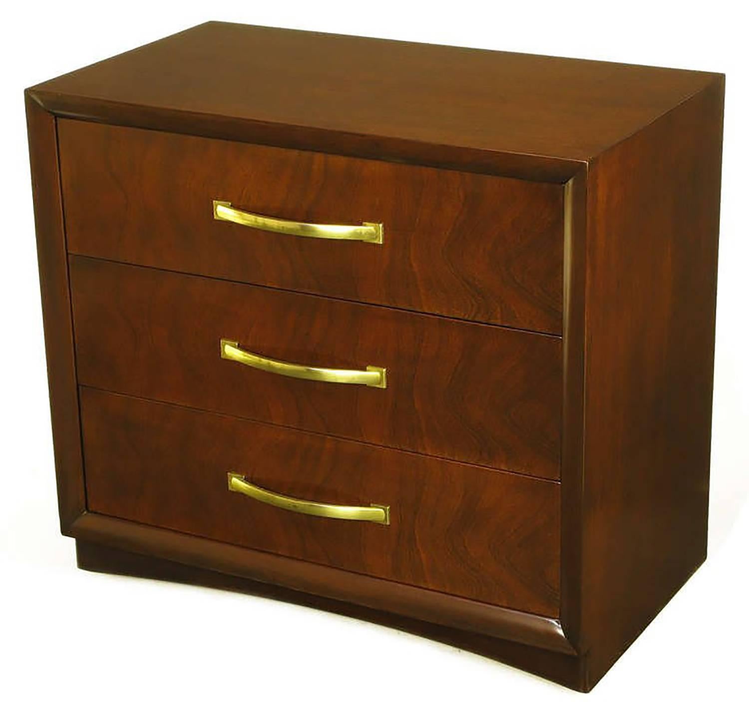 Widdicomb modern original Art Deco three-drawer commode with figured mahogany drawer fronts. Picture frame style casing with recessed curved front plinth base. Large brushed brass curved single pulls for each drawer.