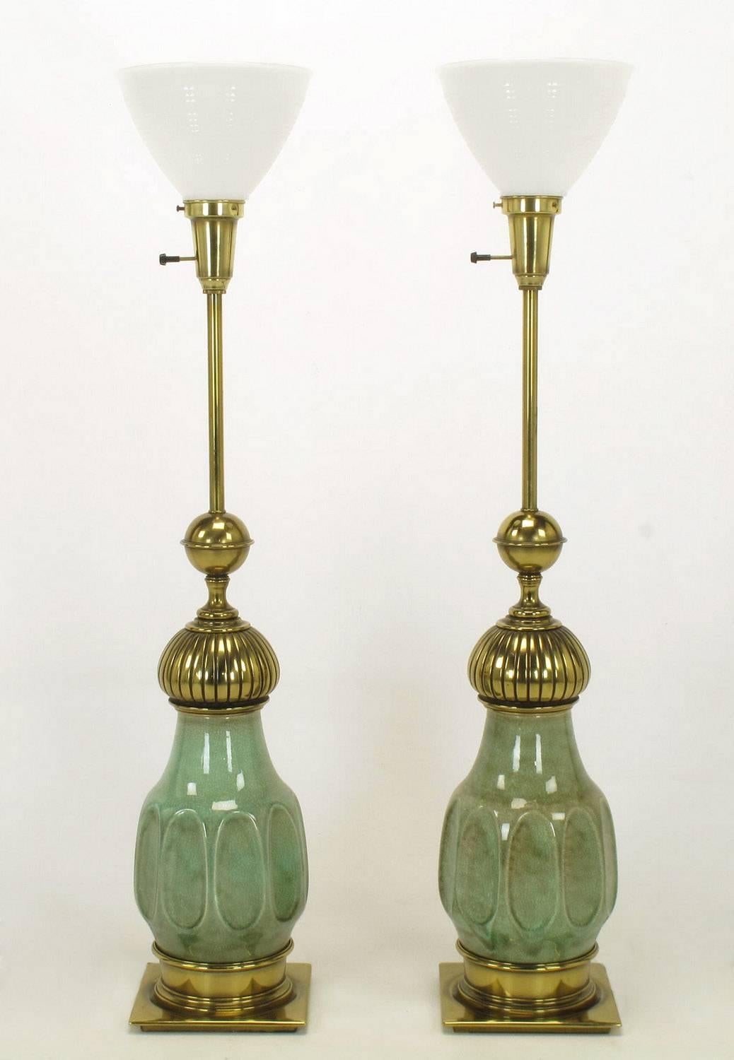 Excellent pair of brass and ceramic bodied Moorish style table lamps by Stiffel. Ceramic bodies are a mottled sea foam green crackle glazed urn form. Brass flat plinth, incised cap and ball, stem and milk glass diffuser. Sold sans shades.