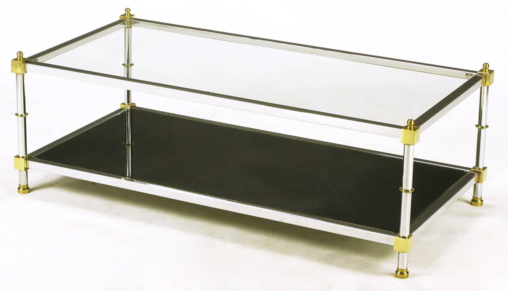 Square stock steel bars with chromed finish and brass block connectors make up this rectangular coffee table. Clear glass top tier with mirrored bottom tier. Brass spacers and feet.