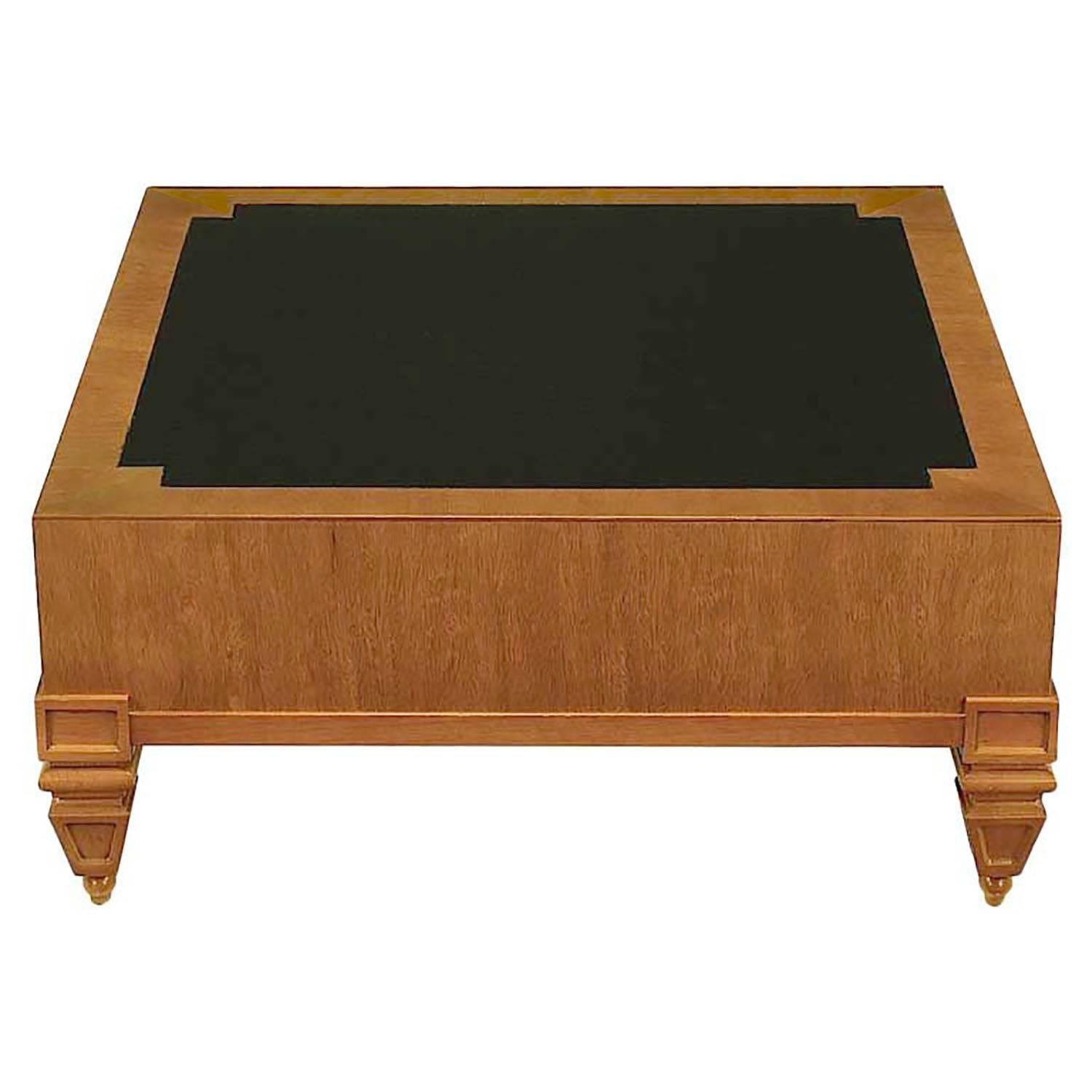 Unexpected and rare Tomlinson square bleached mahogany coffee table with black leather inlaid top. Clean lined with chunky Empire influenced solid mahogany inverted obelisk legs with ball feet. Great size for smaller sofa or in between a pair of