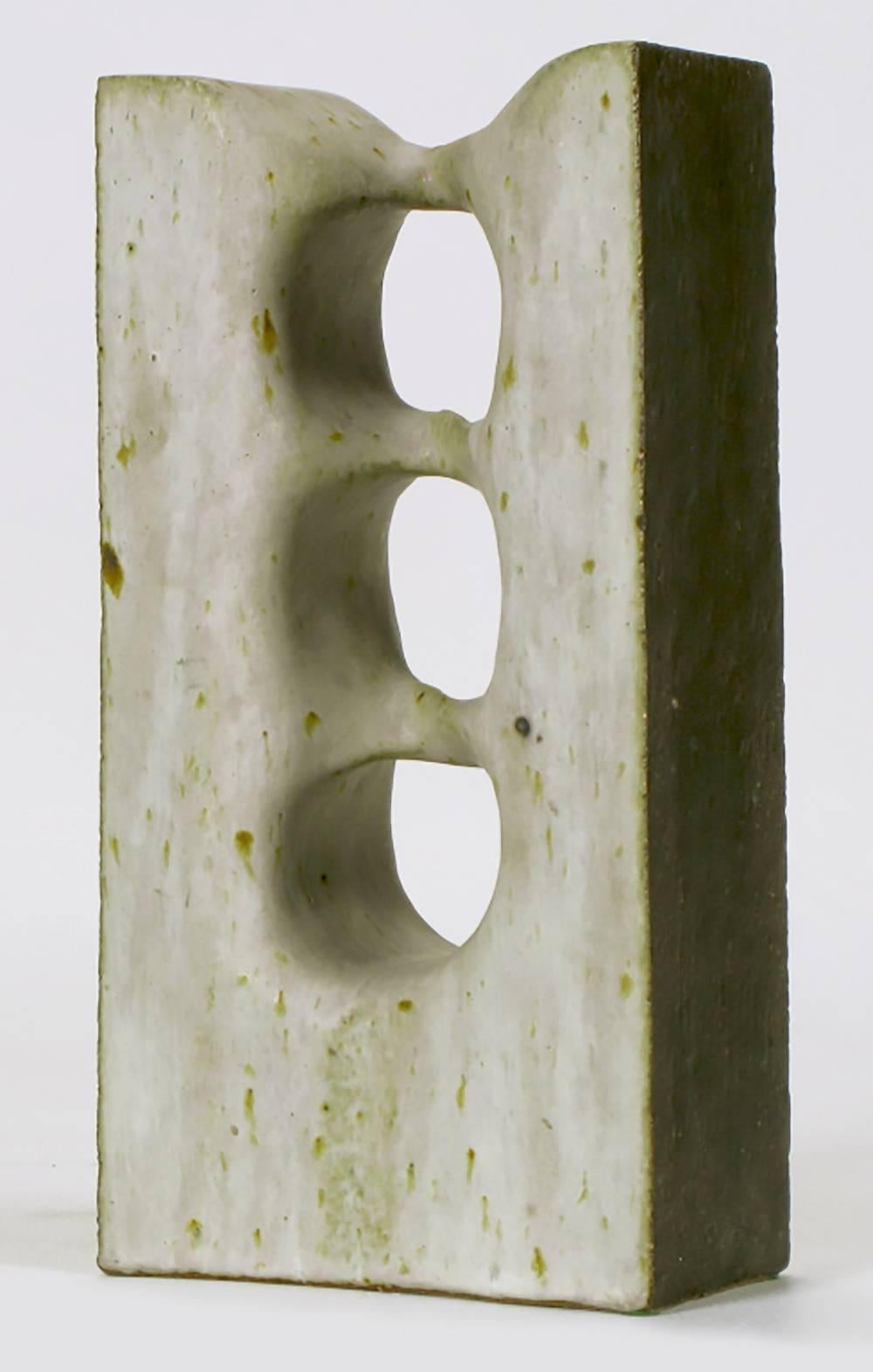 Glazed and pierced vertical abstract sculpture by Tomiya Matsuda, Japanese (1939-2011). Hand molded and cast earthen clay with an off-white matte glaze that has some green tones and heathered markings.

Until 1948, Japanese ceramic artists focused