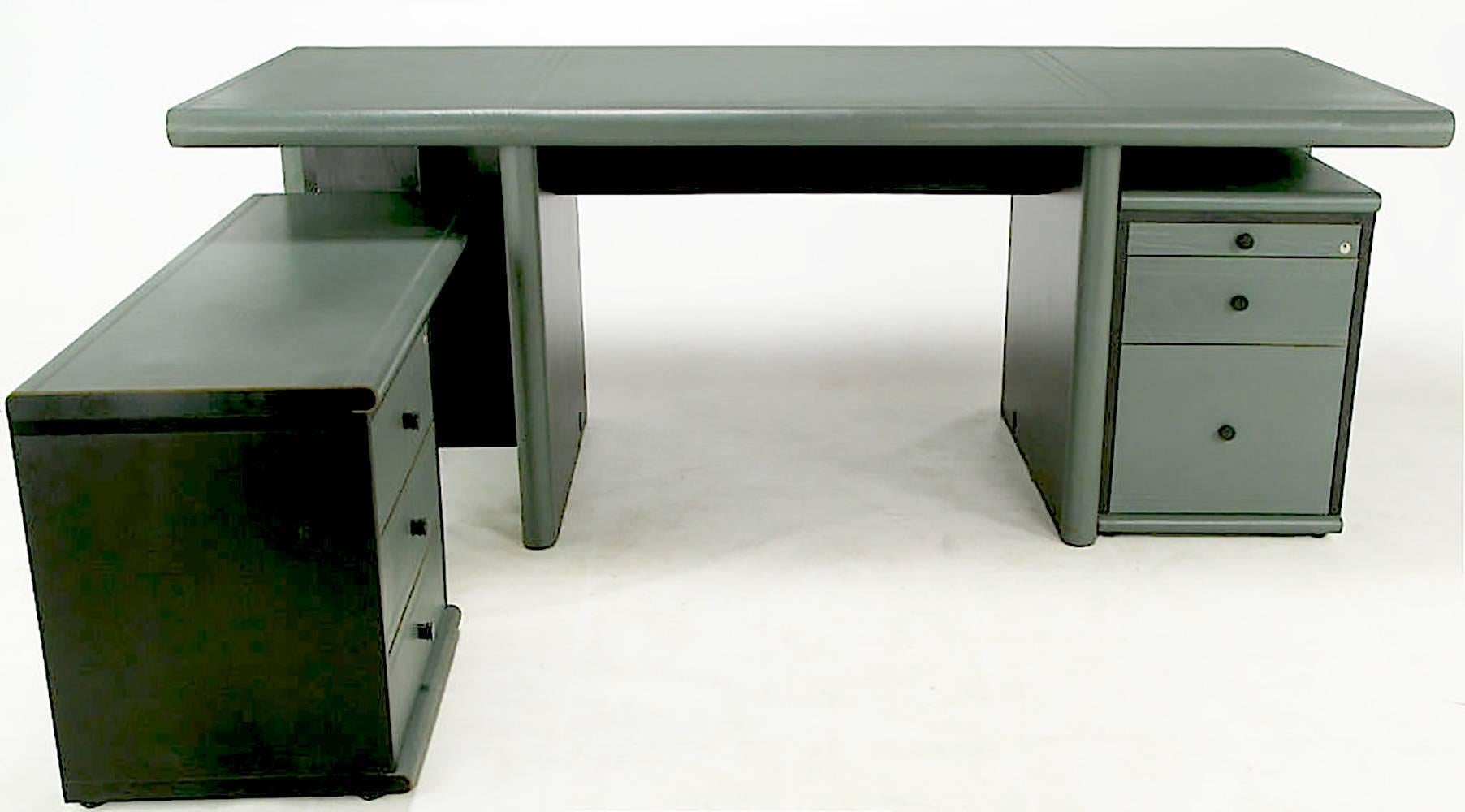 Italian executive desk by Mariani for Pace Collection. Modular desk assembles in pieces for easy adjustments and moving. Teal grey leather has tooled borders where the hides are joined and wraps around the radiused front and back edges of the desk