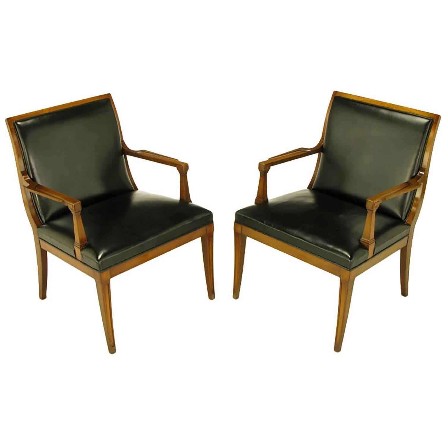 Pair of Stow Davis Italian Regency carved walnut and black leather arm chairs. Curvaceous back and saber legs with recessed panels, block corners and sculpted arms. Black leather seat and back with back panel. From the period when Bert England was
