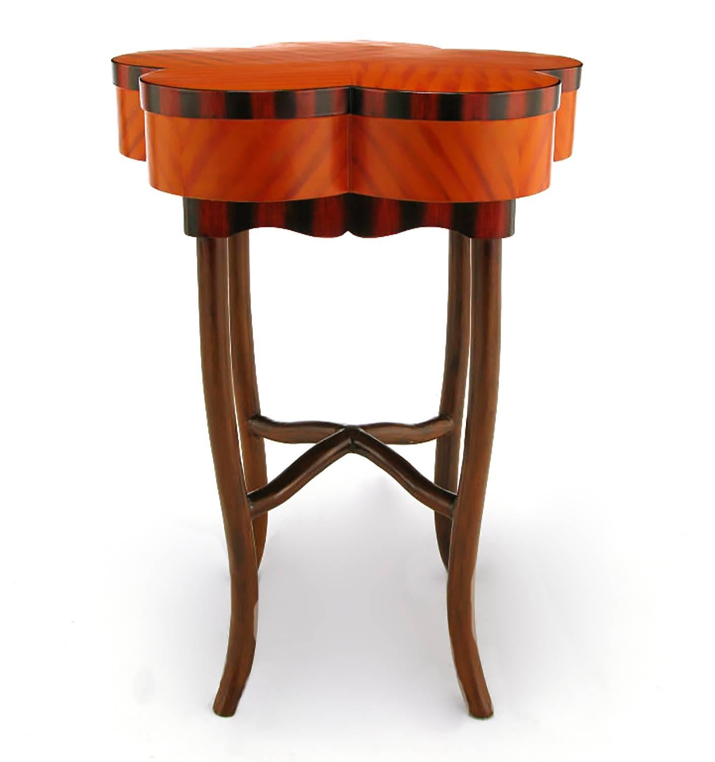 Faux bois side table in a pumpkin and crimson offset patterned pentafoil top with a scarlet and black scalloped skirt. Legs and pyramidal X stretcher are also lacquered to resemble walnut wood grain.