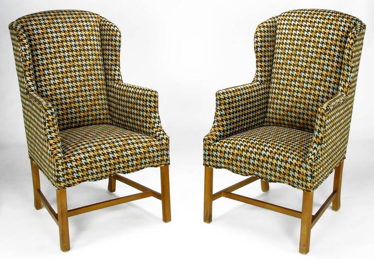Inspired by the 1960s Carnaby Street ethos of unexpected patterns on traditional forms, these wing chairs are wonderfully unexpected. Newly reupholstered in a vintage brown, gray, gold and robin's egg blue wool houndstooth fabric. The long and lean