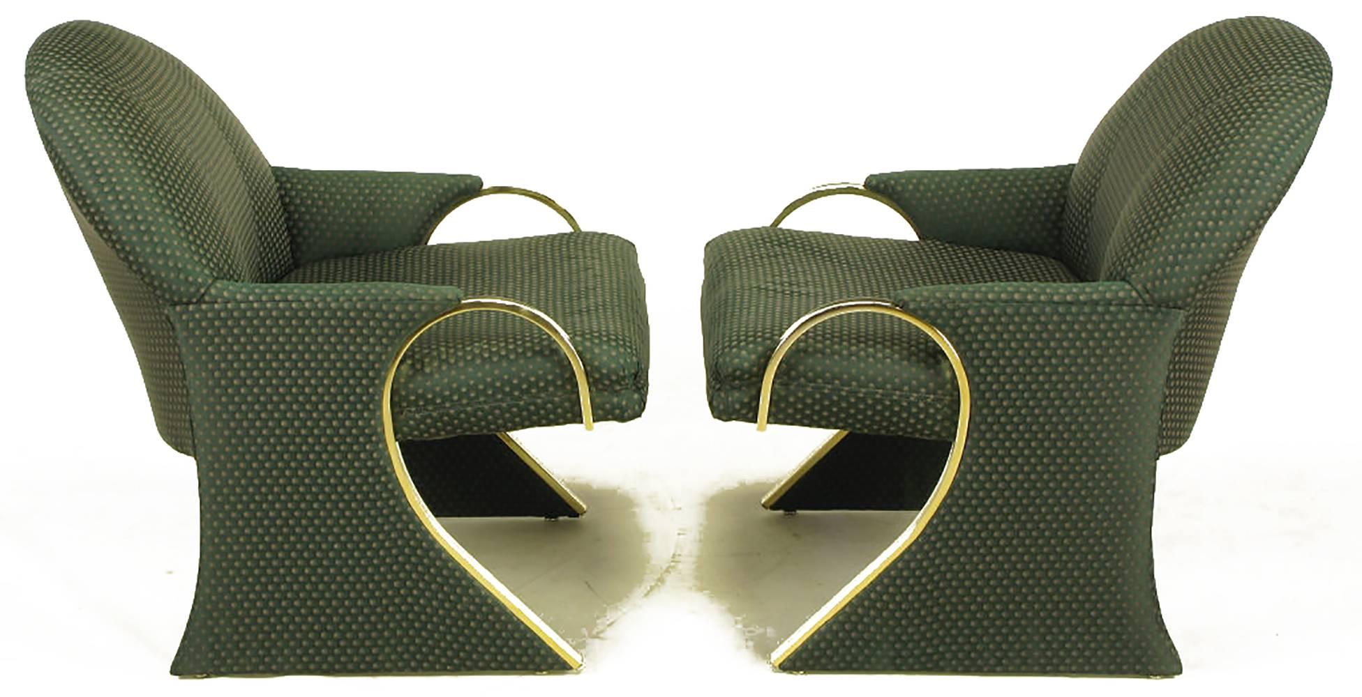 Sculptural sled base Art Deco revival lounge chairs with curved brass detailed arms that continue down the front of the sled base. The arms evoke some designs by Pierre Cardin. Upholstered in a dark green pin point silk blend upholstery.