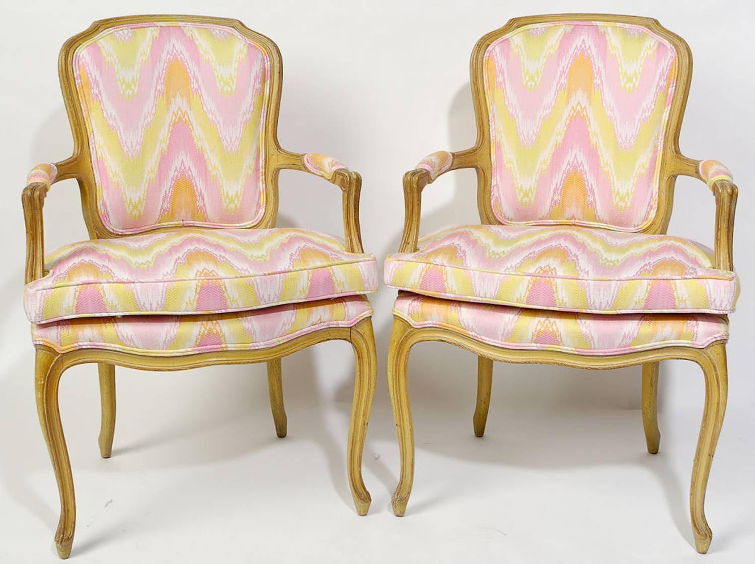 Pair of 1940s Louis XV style open armchairs with original antique glazed and distressed painted finish. Newly upholstered in a vintage pink, yellow, white and apricot flame stitch fabric.