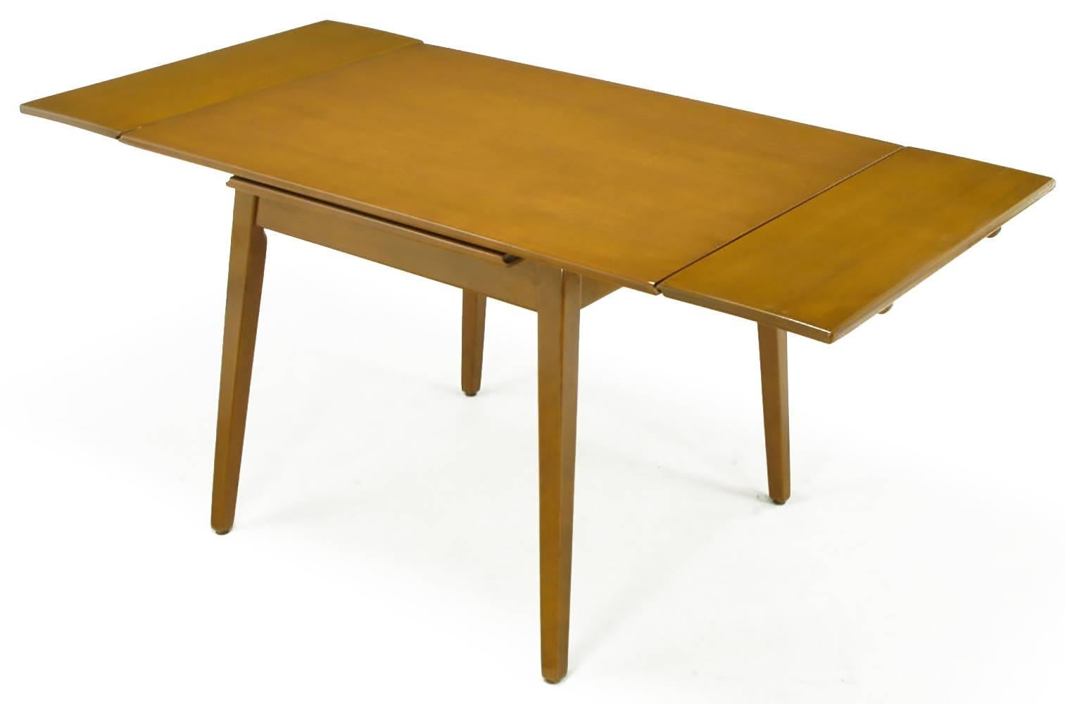 A petite dining table in birch from the Contemporary Line of the Imperial Furniture Company, circa 1950s. Perfect for a smaller space with the ability to expand to 62