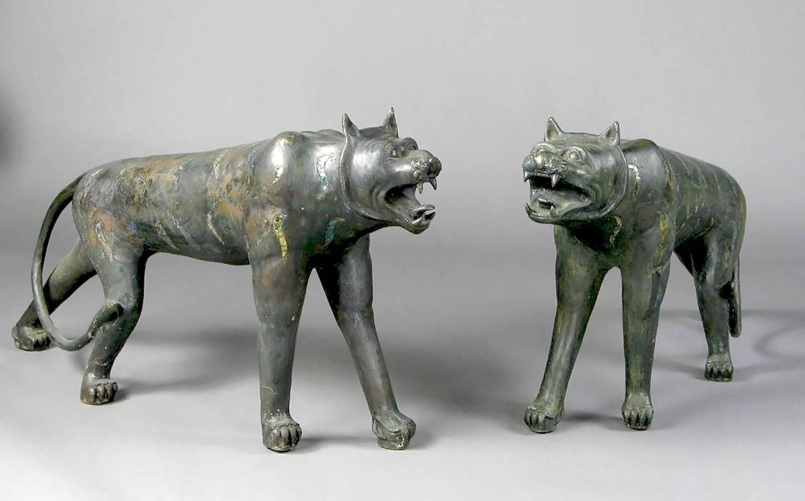 Both striking and rare, these two bronze jungle cats are likely mythological creatures, most closely resembling tigers or leopards. A matched pair, one is slightly larger than the other and their patinated bronze surface is adorned with polychrome