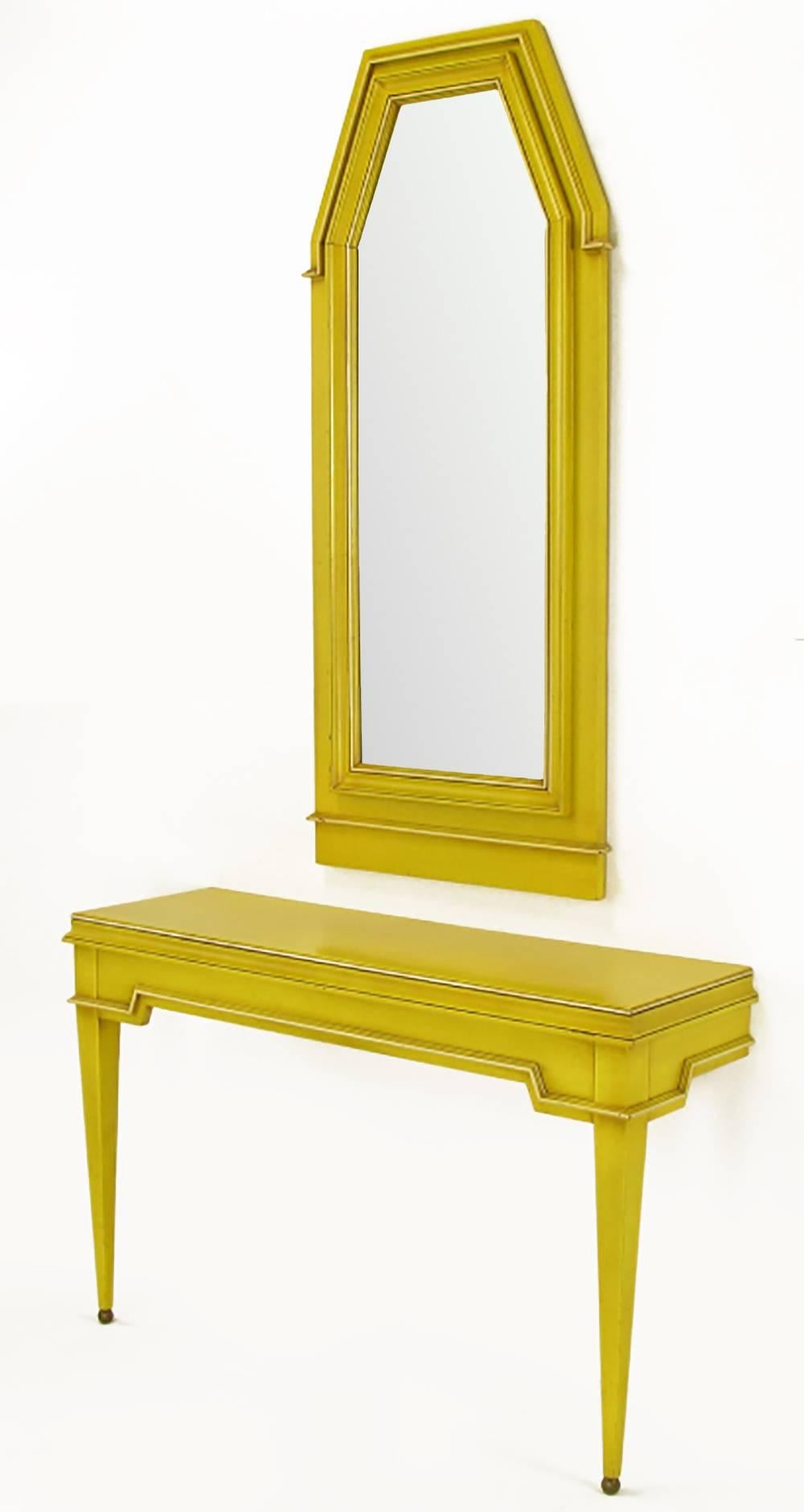 Elegant empire style wall-mounted console, with spherical solid brass feet, and matching pentagonal mirror. Finished in yellow lacquer with an umber glaze. Wonderful contrast of color and style that works with both traditional and contemporary