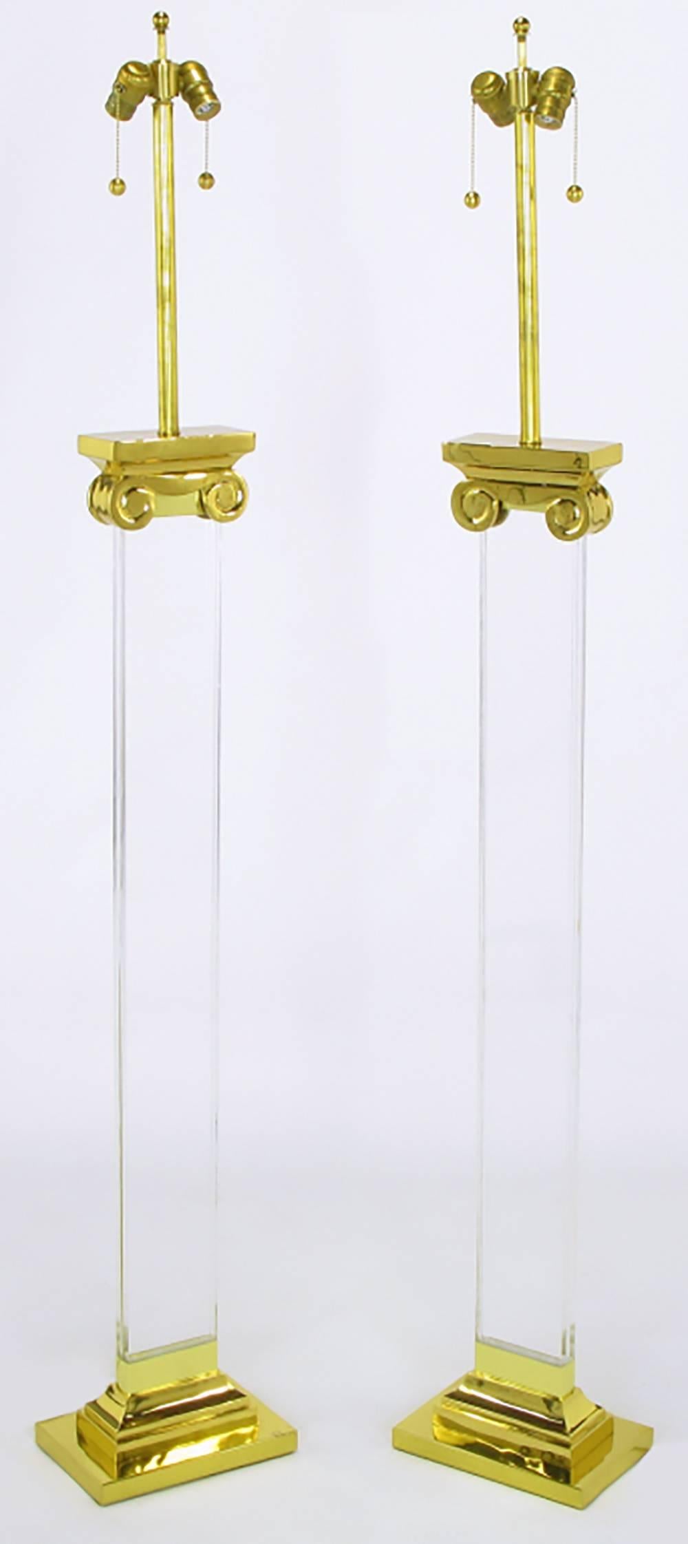 Neoclassical pair of acrylic and brass ionic column floor lamps. Brass base and capitals, double socket cluster and stem with one inch thick Lucite column body.