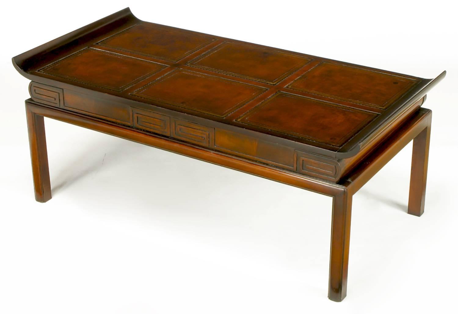Asian inspired coffee table with curved edge tops and tooled leather inlay. The fronts and finished backs have Greek key carved recesses. Radius front legs and back legs. See our other listings for the matching side tables.