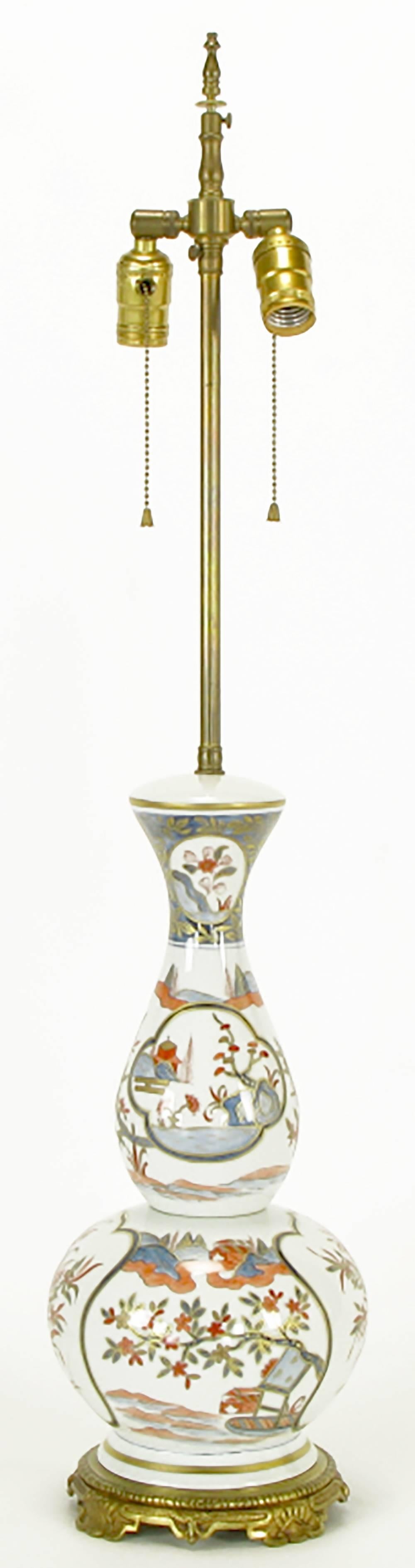 Lampada da tavolo di ispirazione asiatica dipinta a mano. Corpo in porcellana realizzato a Parigi in Francia, dipinto a mano da J Poncet, base in ottone e gruppo di prese doppie in ottone con interruttori a catena. Venduto senza paralume.