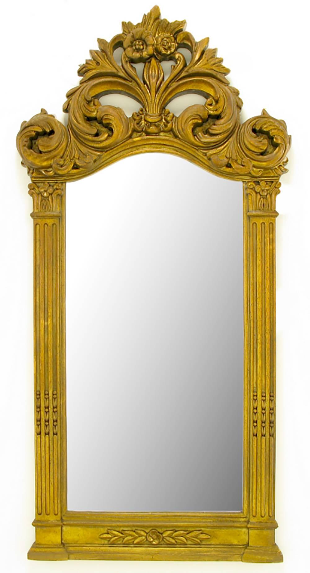 Large and impressive pair of aged gilt Rococo style framed mirrors with pierced and foliate detailed crowns. Could be used over a pair of consoles or in a double vanity bathroom.