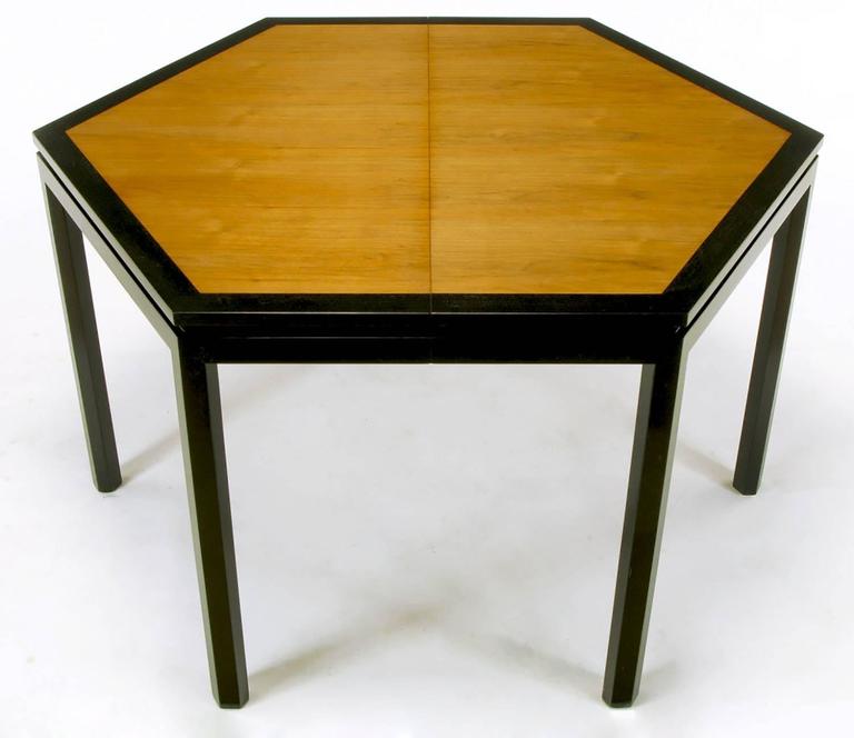 Uncommon hexagonal dining table by Edward Wormley for Dunbar. Tawi wood top, bordered with ebonized mahogany. Ebonized mahogany legs and notched apron. Sold with three offset grain Tawi wood 16