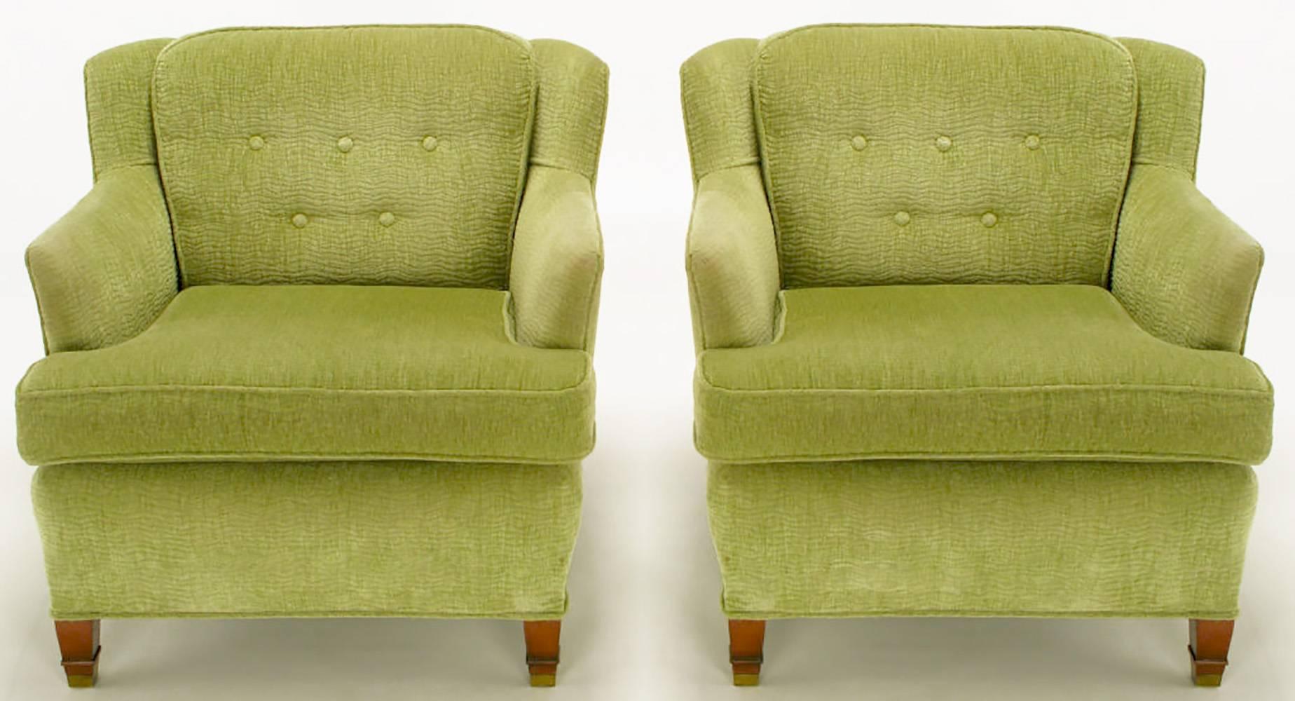 Pair of low lounge chairs with fixed button tufted back cushion and slight wing. Loose seat cushion, mahogany legs with raised detail and brass sabots to the front. Upholstered in a sage colored, cut to stripe, chenille.