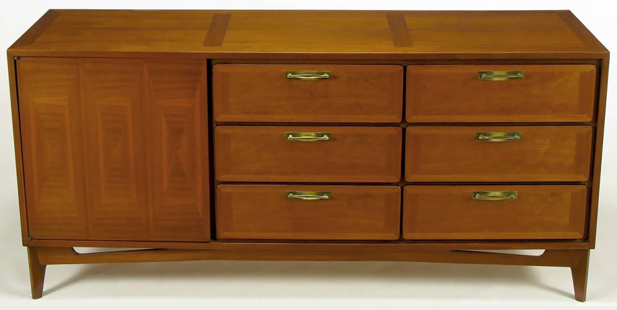 Excellent build quality and design for this, circa 1950s modern nine-drawer long dresser. Beautifully wood grained mahogany parquetry front door that opens to reveal three sliding drawers. Six additional parquetry front drawers have patinated brass