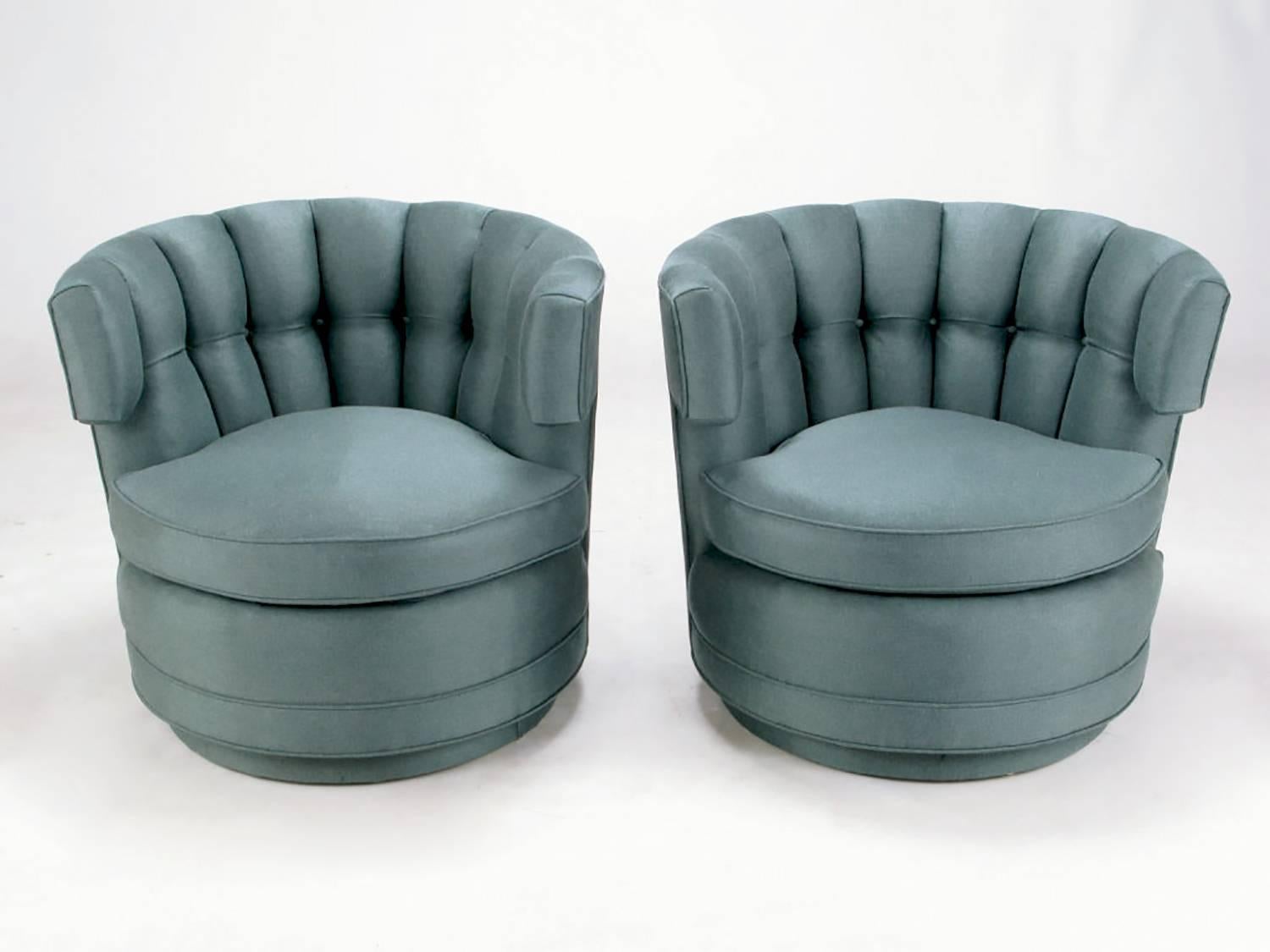 Very much in the style of James Mont and Billy Haines, these amazing button-tufted barrel-form swivel chairs have been restored from the ground up. New silvery cadet blue upholstery, new cushions and stuffing, even the swivel mechanism is new.