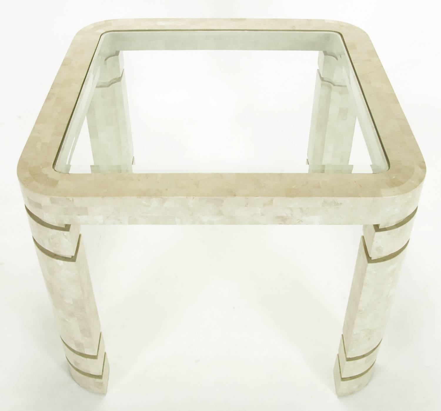 Tessellated fossil stone game table after designs by Karl Springer. Radius corner legs with unexpected double incisions, thick table surround or apron and beveled edge glass top. Likely from the same Philippines manufacturer used by Karl Springer