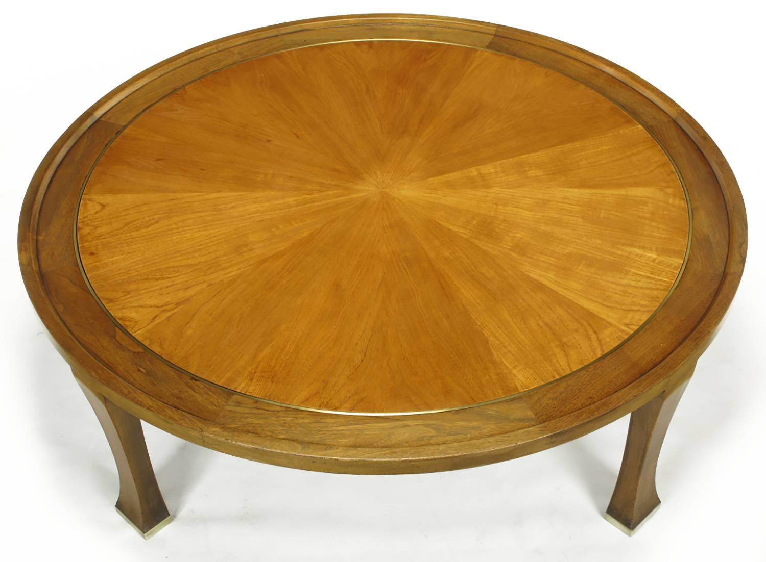 Round parquetry top coffee table designed for Baker Furniture. Unusual styling with tapered legs that widen at the brass capped foot. Round top is comprised of a tapered mahogany frame with a lipped outer edge. Brass banded inset detail separates
