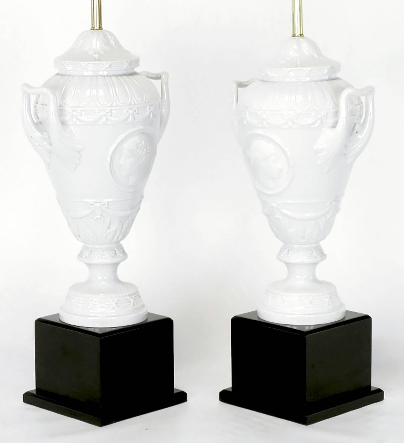 Lacquered Pair of White Porcelain Urn Table Lamps with Male and Female Busts in Relief For Sale