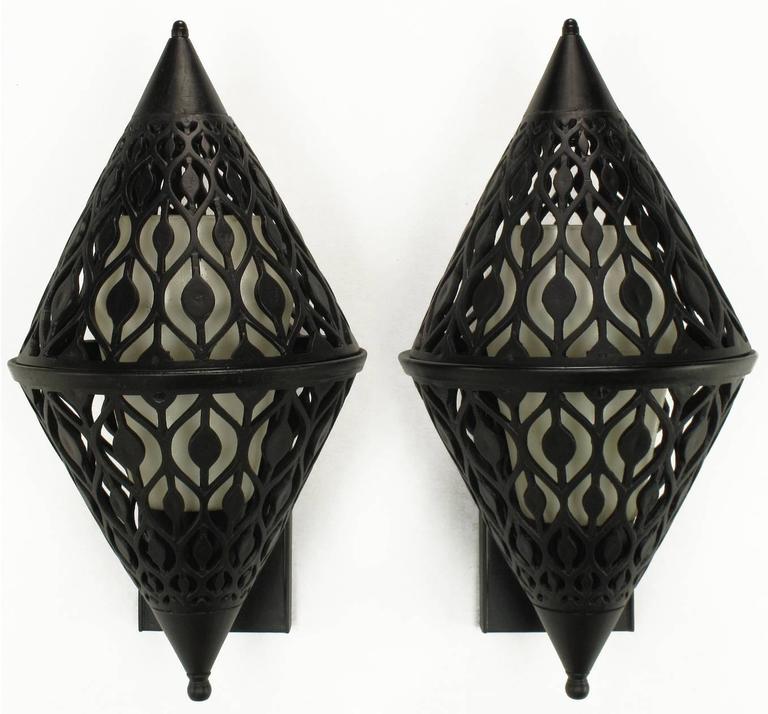 Restored pair of Gothic inspired black enameled and pierced aluminum sconces. Diamond shaped with rectangular back plate. Most probably of French origin, internal milk glass shades with threaded porcelain sockets and fitter rings. Can be hung as