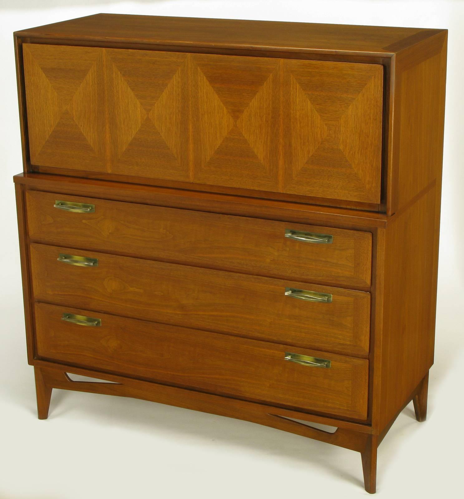 Excellent build quality and design for this circa 1950s modern five-drawer tall dresser. Beautifully wood grained mahogany parquetry front drop down door opens to reveal two siding drawers with sectioned interiors. Three lower drawer have patinated