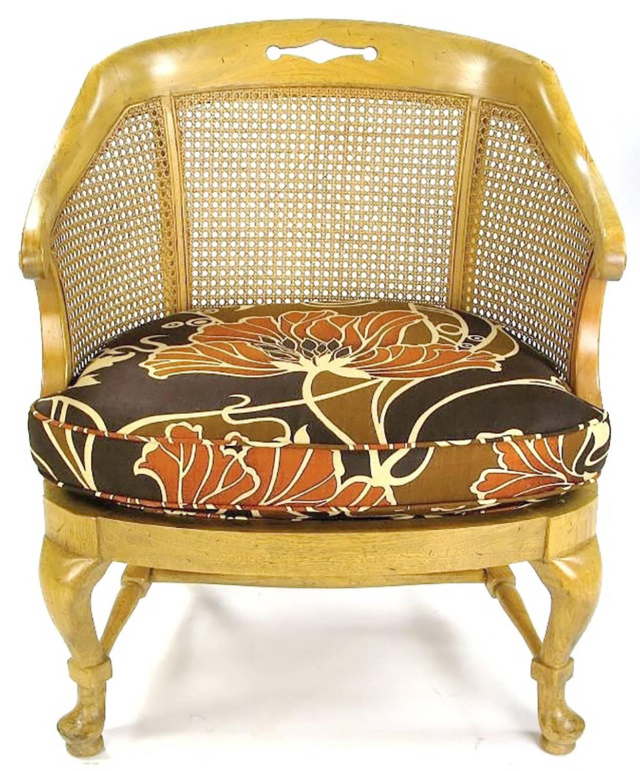 Bleached mahogany cabriole leg Regency style bergere armchairs with woven cane back and sides. Cross stretcher base with rectangular box joinery. New large print vintage fabric. $3,250.