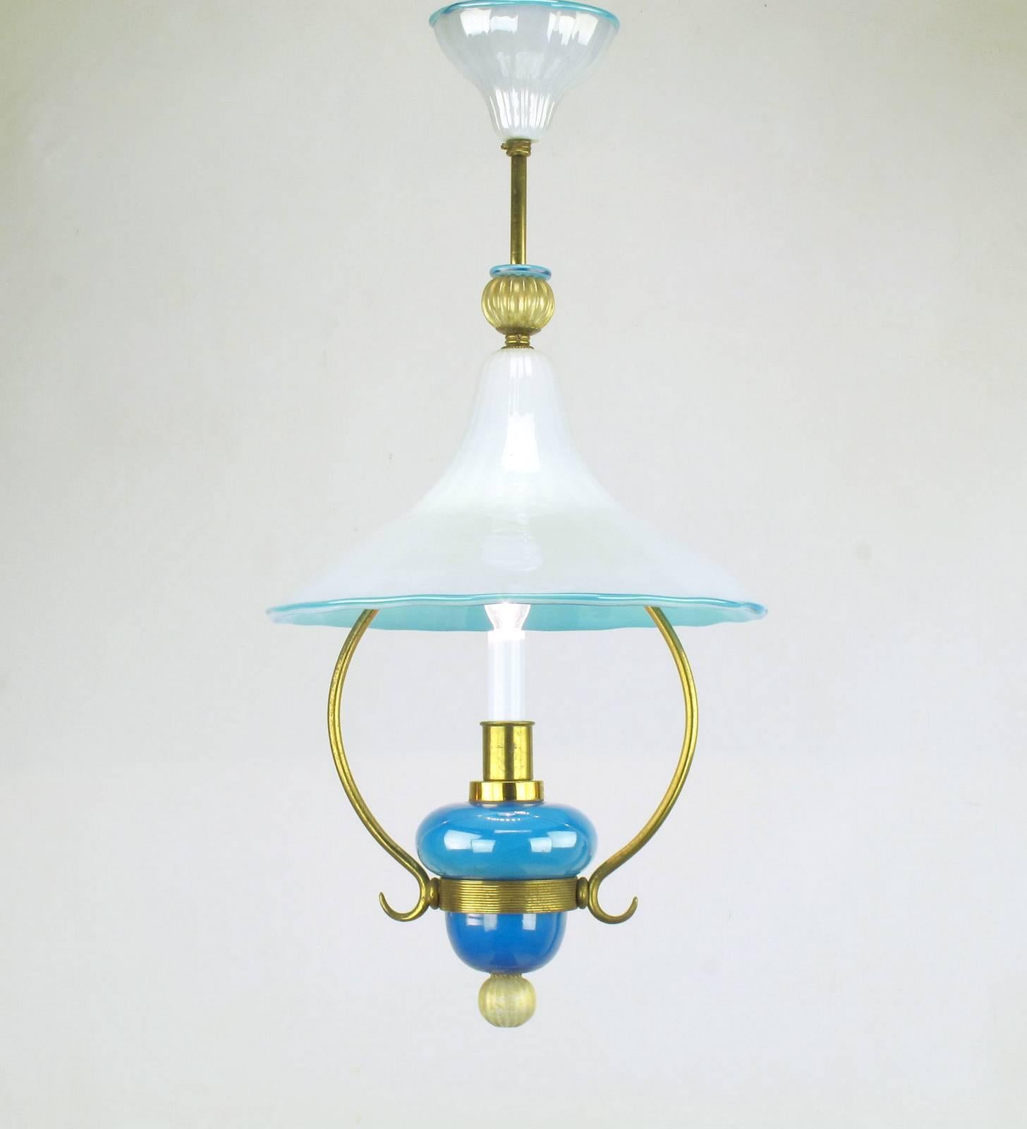 Exceptional handblown Italian Murano cased glass pendant light with brass frame. Blue and white cased glass canopy, hooded shade and body with gold flecked finals to the top and bottom. Made to look like a vintage kerosene light, this has been wired