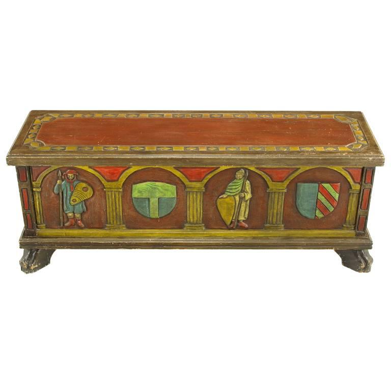 Artes De Mexico hand-painted blanket chest or trunk. Spanish Revival themes of familial crests and warriors are carved into the wood front, back and sides and hand-painted. Top has a carved and hand-painted border with a scarlet center as well as a