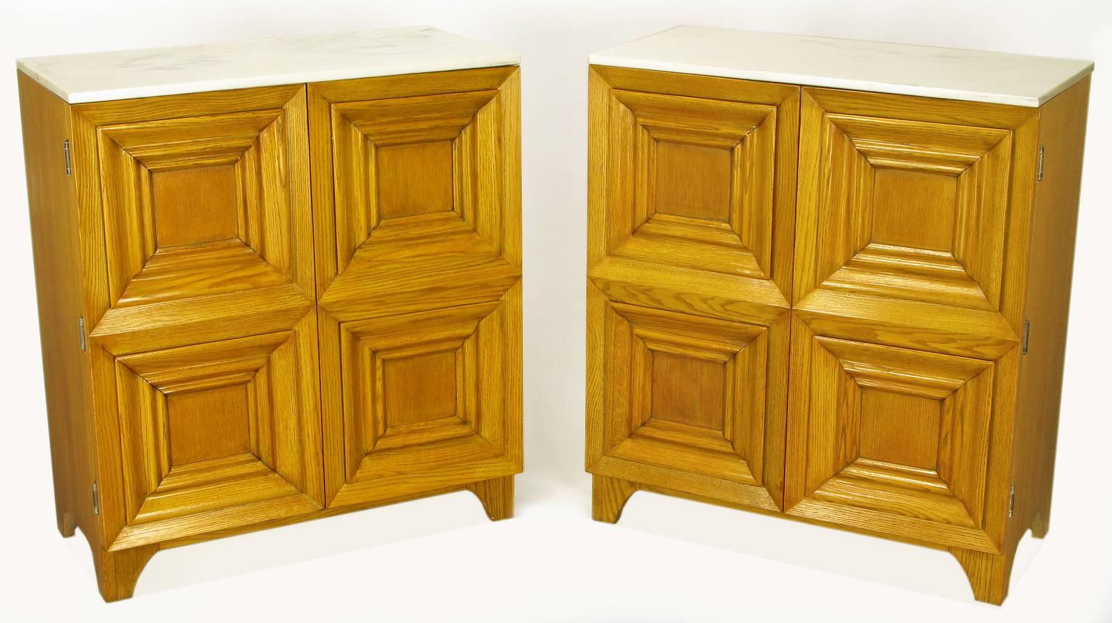 Pair of four panel carved and recessed front cabinets constructed of solid white oak. Each four panel front is constructed of bi-fold doors that open to reveal five drawers, three with partitions. Clean, elegant radiused bracket style front and rear