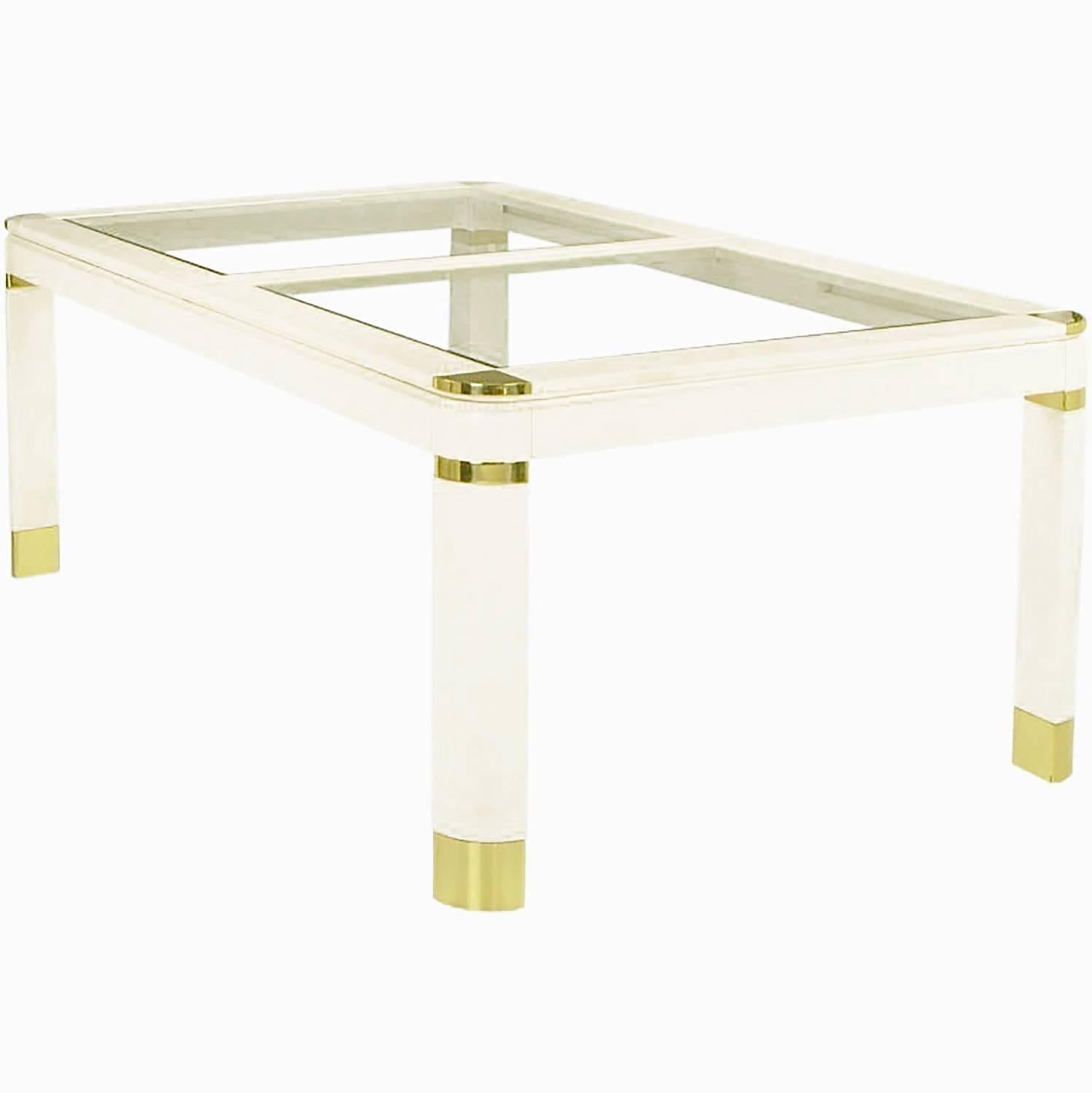 Superb dining table in ivory lacquer over wood, with two one-half inch thick beveled glass inserts. Accented by brass sabots, banding, and corners. With two solid wood ivory lacquered 20