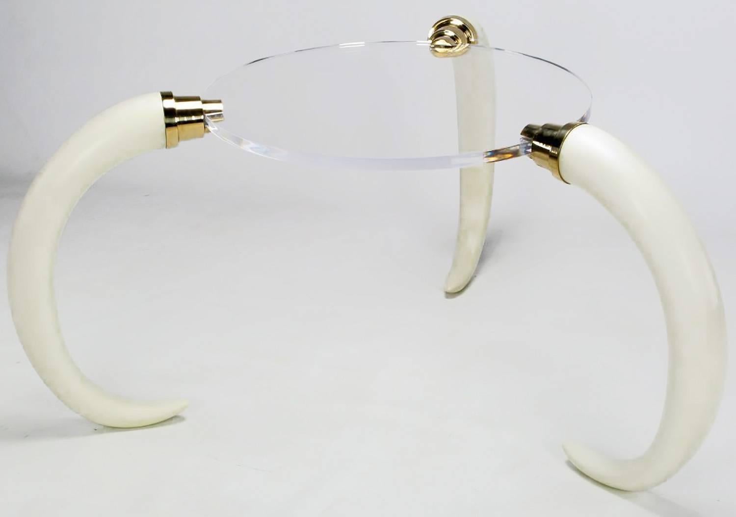A one-of-a-kind center table consisting of three faux elephant tusks with heavy brass hardware and a 1