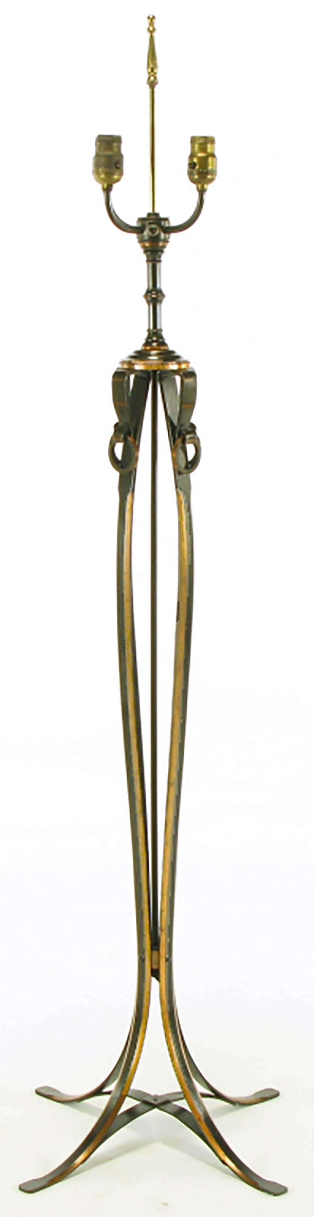 Bronze strap floor lamp with copper accents. Four bronze/copper straps make up the four leg base with a convex X-stretcher. The straps rise up, flare out in the middle and then come together to make then support for the stepped cap. Each bronze is