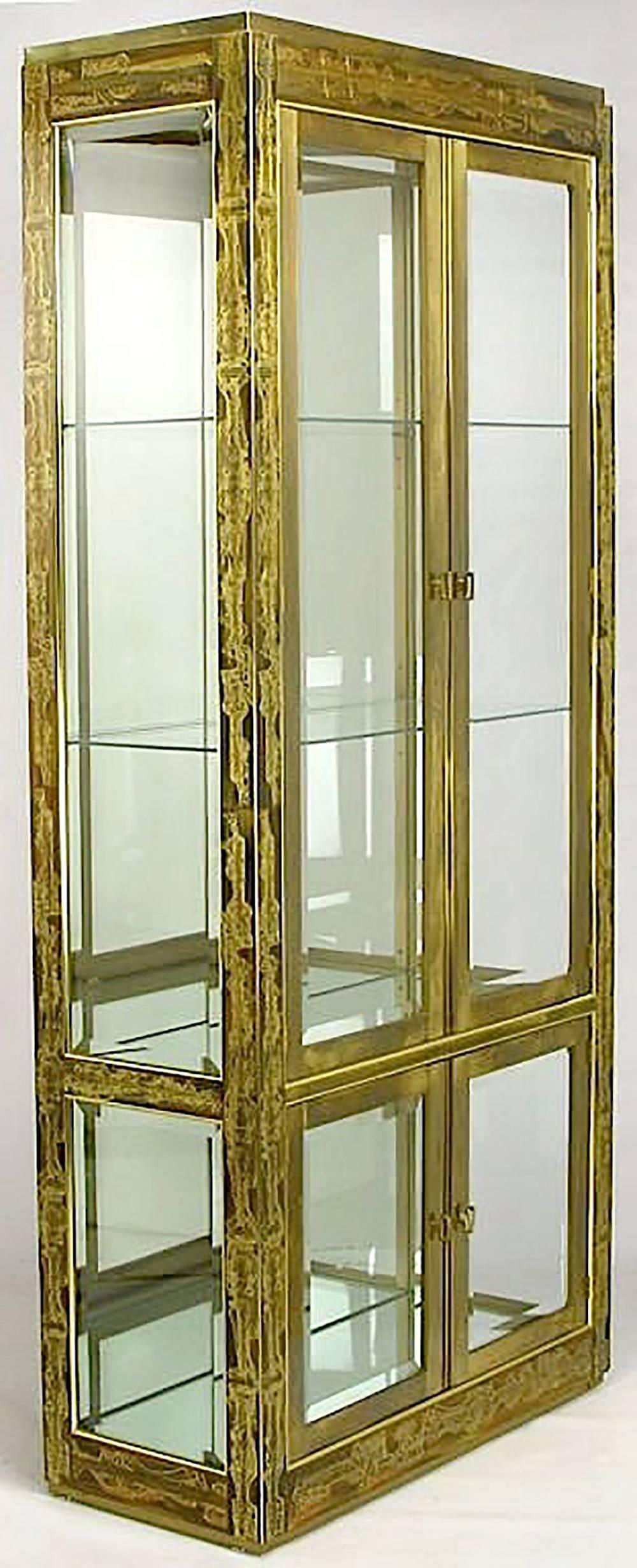 Pair of Mastercraft brass vitrines with the entire casing clad in acid etched panels by the Canadian artist, Bernhard Rohne... Each cabinet has four doors that are heavy brass wrapped glass panels with solid brass open rectangular pulls. The crown
