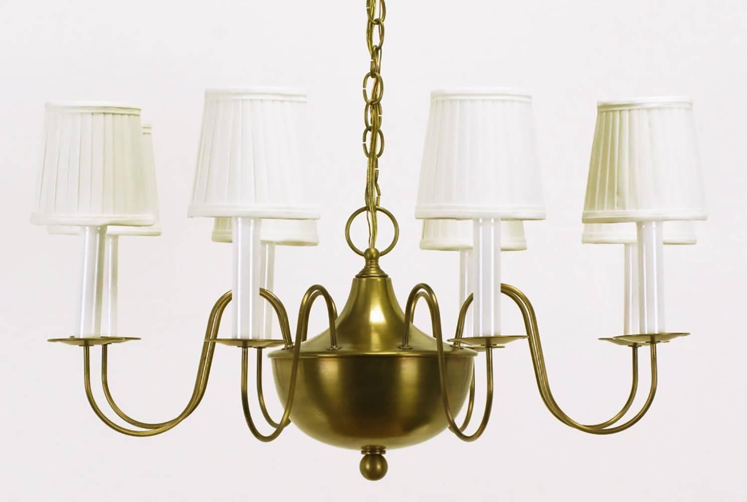Very well designed and finely constructed spun brass bowl eight-arm chandelier. Nods to French Regency styling with the slender brass S shaped arms with petite disc bobeches, spun brass bowl with flanged cap and large closed ringed finial.
Drop is