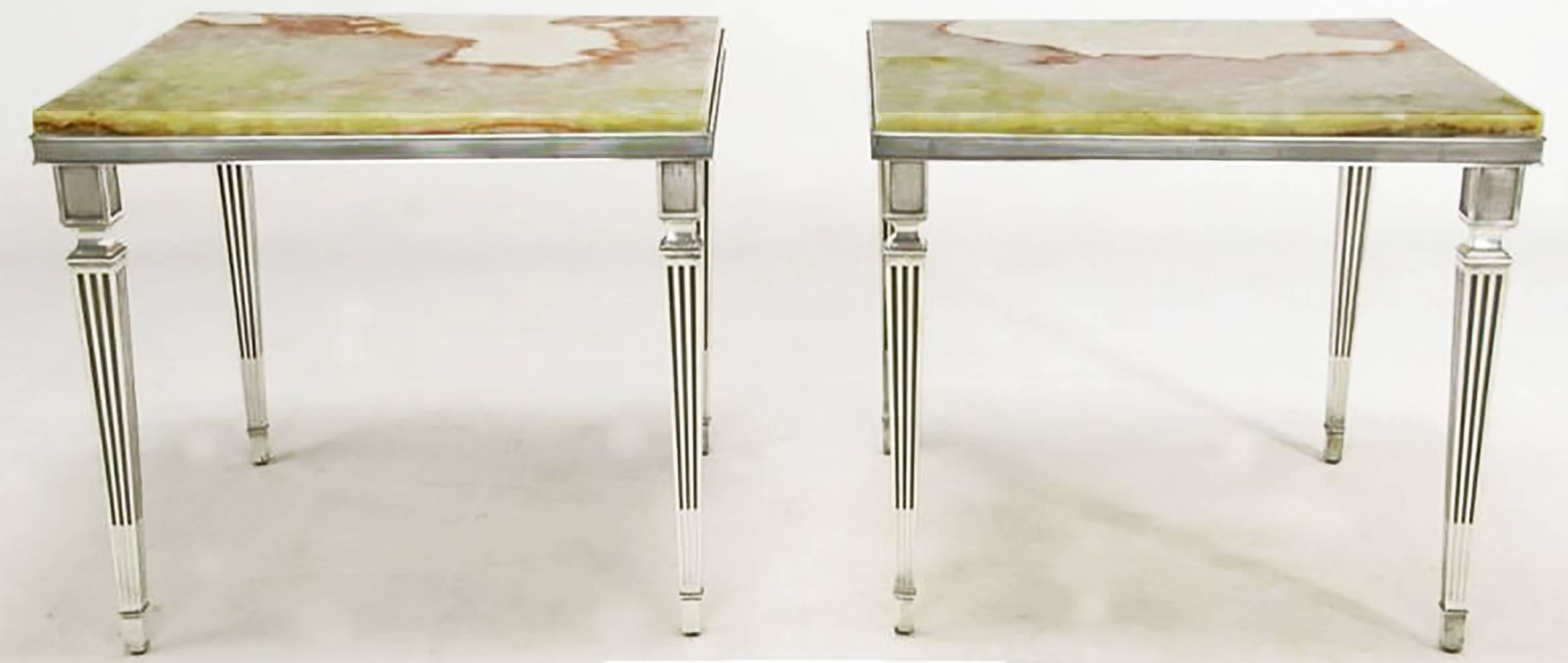 A very substantial pair of neoclassical end tables in the manner of Maison Jansen. This exquisite pair are constructed of solid silverplated bronze. Bronze Louis XVI-style tapered legs and banded ribbon sides support the onyx tops of red, cream and