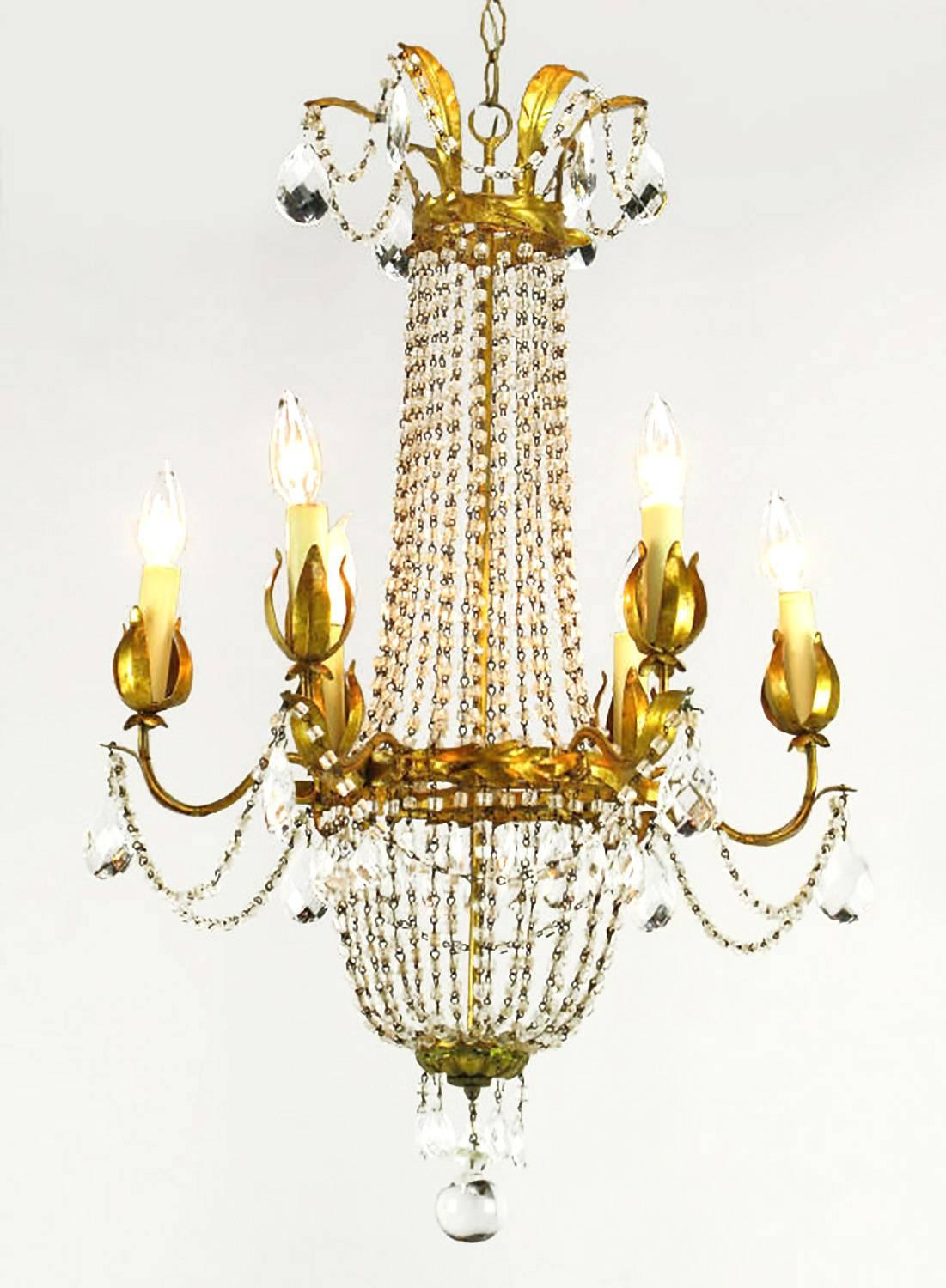 Elegant gilt Italian tole metal and iron crystal basket form chandelier with six arms. Adorned with real wax and pressed paper tube candles, draped with cut pear-shaped crystals and crystal strands. It is finished with a large crystal sphere