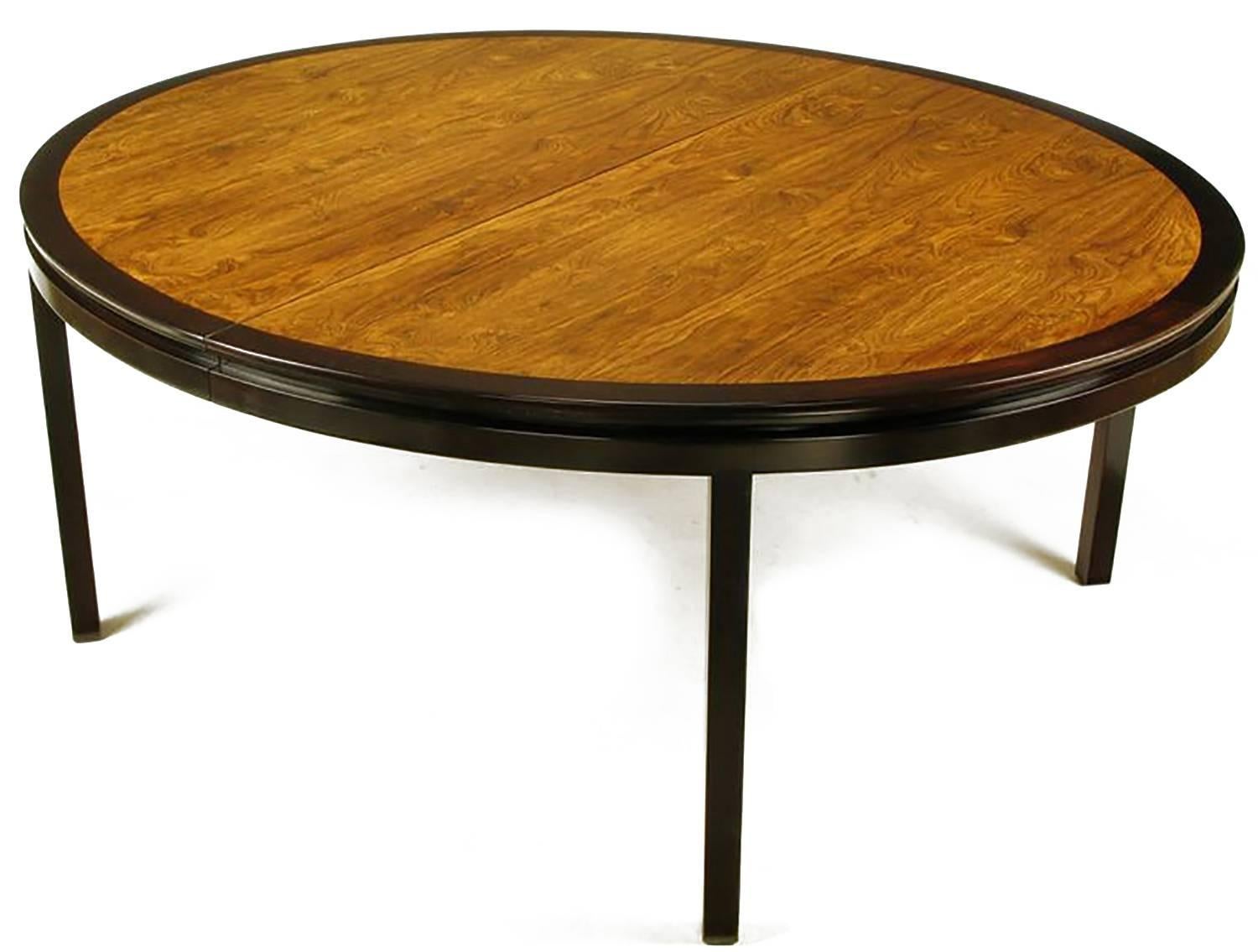 Outstanding custom-made large oval dining table designed by Edward Wormley for Dunbar. Dark stained mahogany border, incised apron and squared legs. Inlaid bookmatched rosewood veneer top is beautifully grained. Restored to like new condition.
