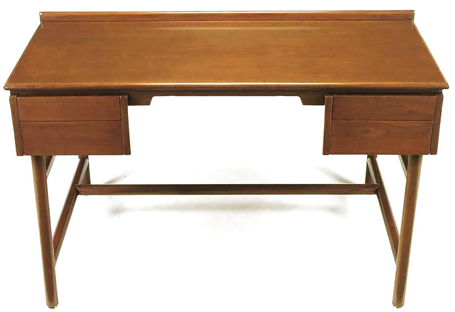 Walnut desk by William Pahlmann with four drawers and front shelf. Unusual base of large intersecting dowels. Restored to outstanding original condition. From Pahlmann's 1952 Hastings Square Collection for Grand Rapids bookcase and chair company.
